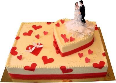 Eine Hochzeitstorte mit einer Braut- und Bräutigamfigur obenauf