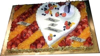 Ein herzförmiger Kuchen mit Erdbeeren darauf