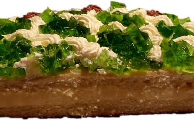 Eine Nahaufnahme eines Kuchenstücks mit grünem Zuckerguss obenauf.