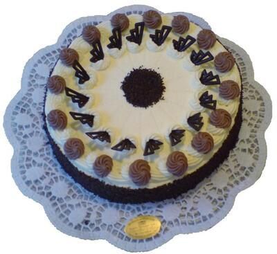 Ein Schokoladenkuchen mit weißem Zuckerguss und Schokostreuseln