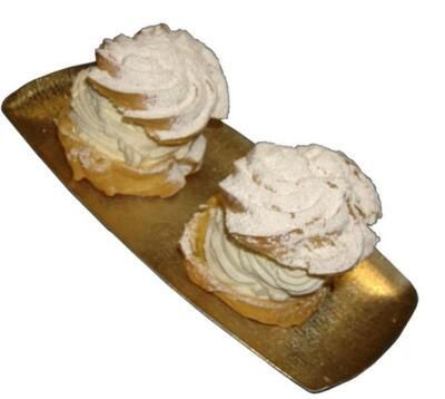 Zwei Cupcakes mit Schlagsahne auf einem goldenen Tablett