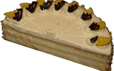 Ein Stück Kuchen mit Schlagsahne und Schokoladenherzen obenauf