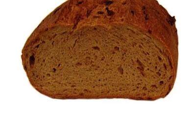 Eine Nahaufnahme einer Scheibe Brot auf weißem Hintergrund.