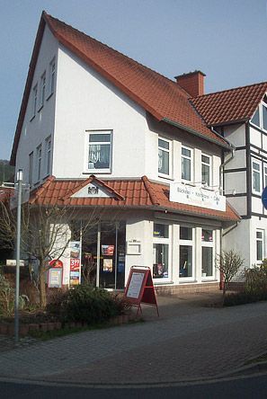 Ein großes weißes Gebäude mit einem roten Ziegeldach