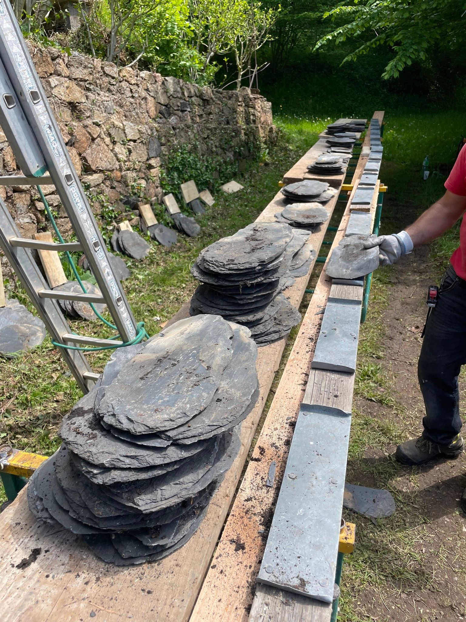 Un ouvrier avec des gants devant des disques en pierre