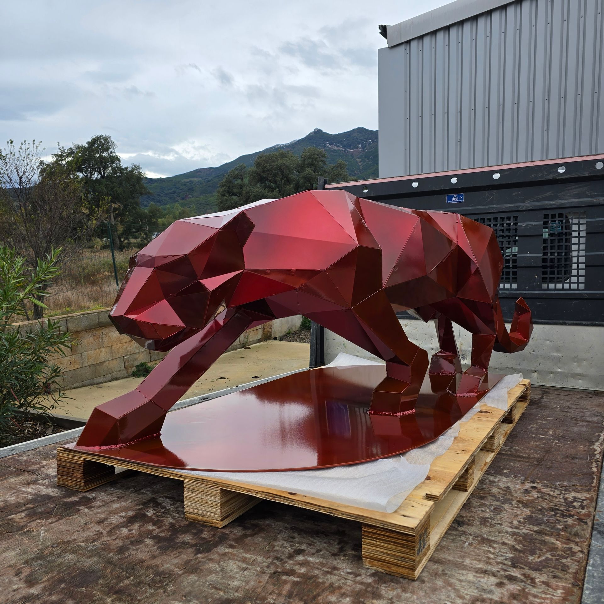 Sculpture de pieuvre en métal avec un design découpé complexe, reposant sur une surface métallique.