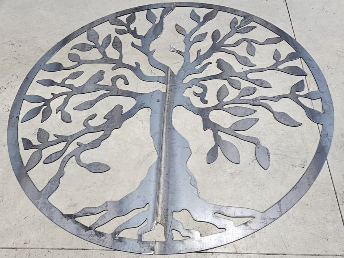 Silhouette d'arbre de vie en métal dans un cadre circulaire.