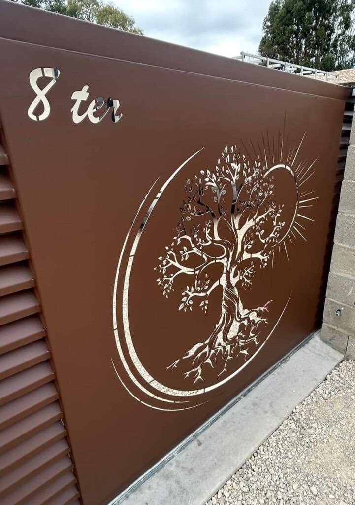 Portail en métal marron avec adresse 8 ter et découpe en forme d'arbre.