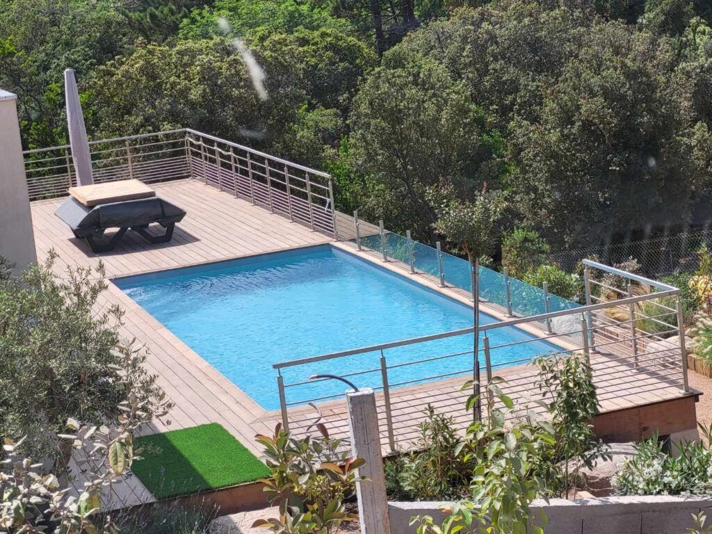 Garde-corps en métal noir avec motif géométrique le long d'un extérieur en stuc gris.