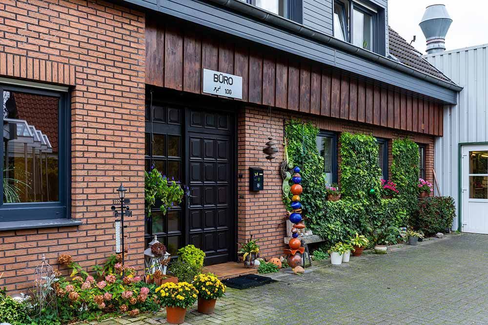 eine rote Backsteinmauer mit einer schwarzen Tür und einem Schild mit der Aufschrift boro