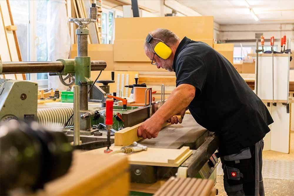 ein mann arbeitet an einer maschine und trägt kopfhörer