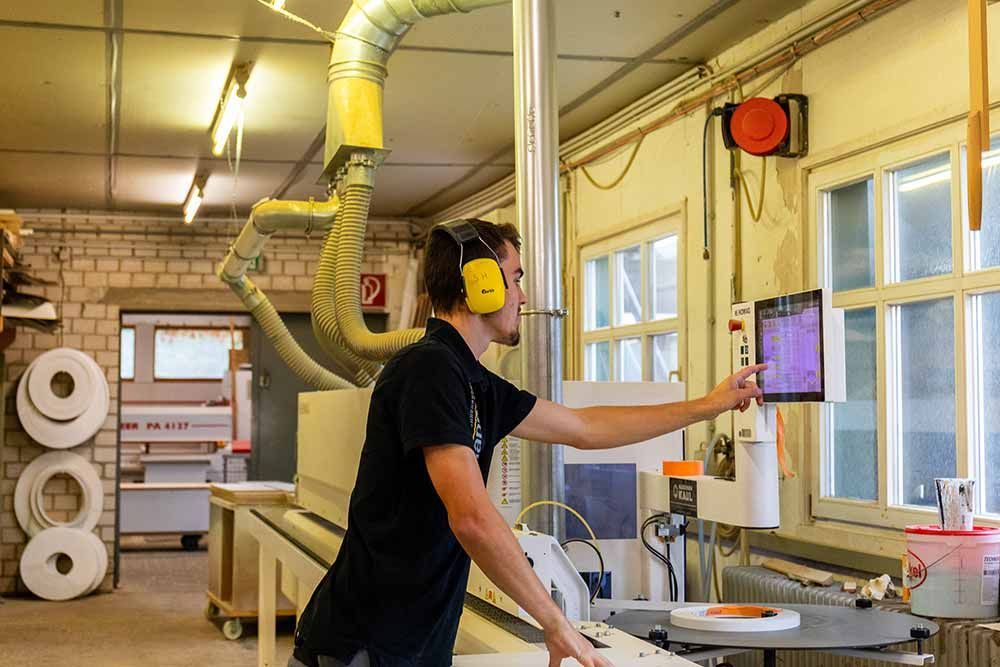 ein mann arbeitet an einer maschine mit kopfhörern