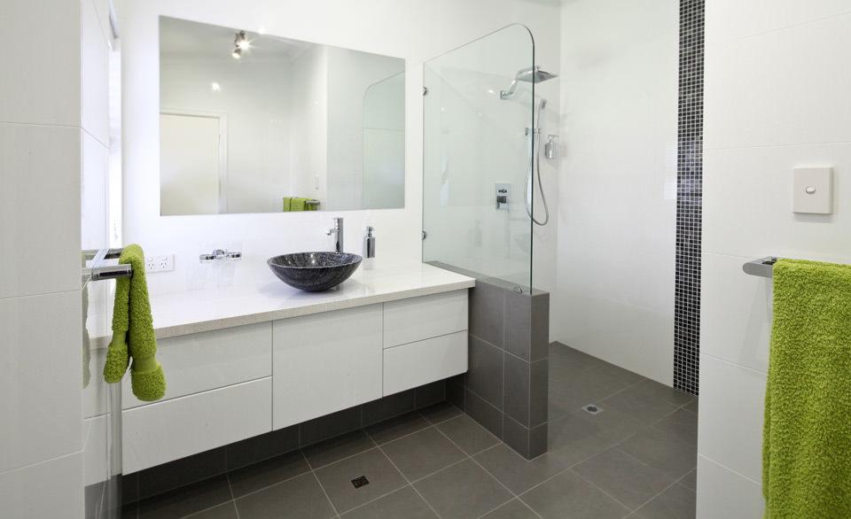 Une salle de bain avec lavabo, miroir et douche à l'italienne.