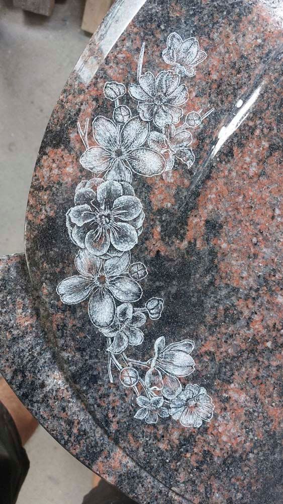 Eine Nahaufnahme eines Granittisches mit Blumen darauf.