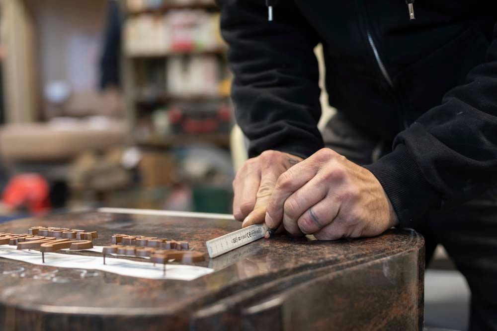 Ein Mann arbeitet in einer Garage an einem Stück Holz.