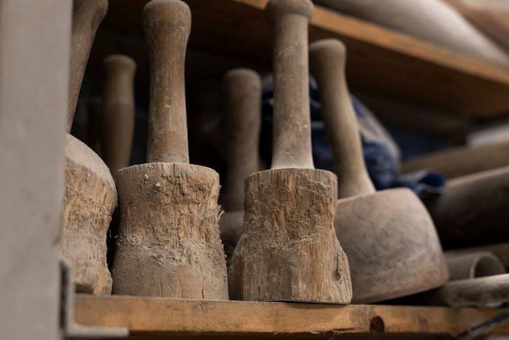 Auf einem Holzregal liegt ein Haufen Holzwerkzeuge.