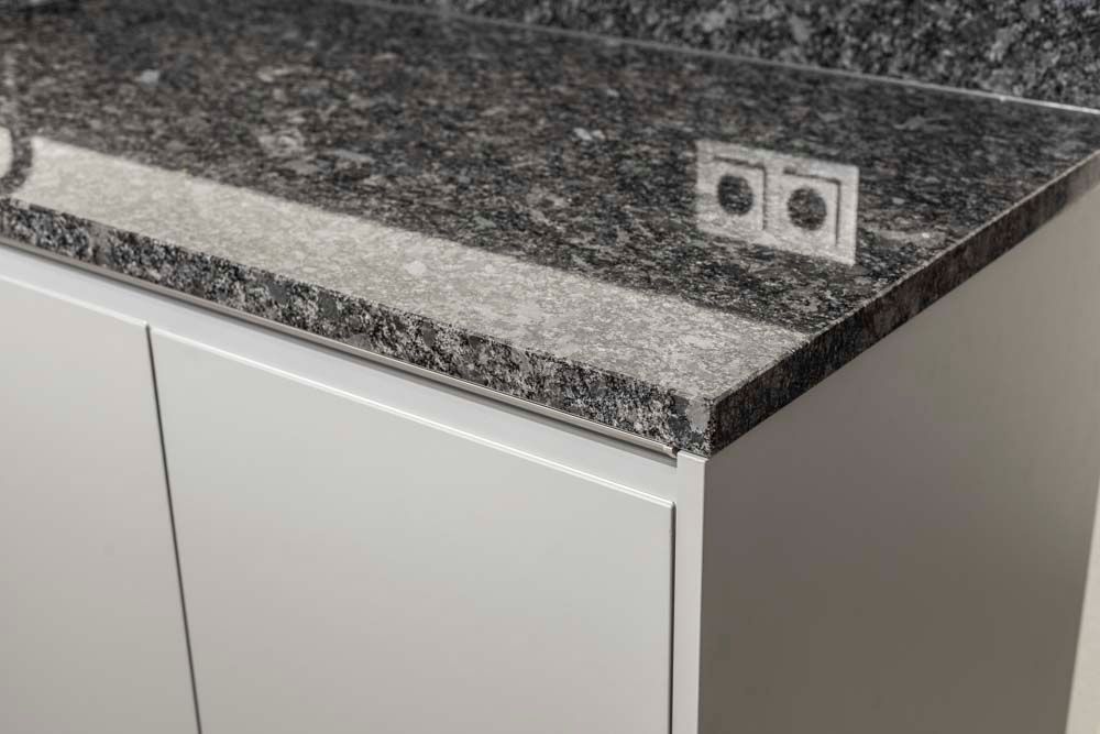 Eine Küchentheke mit Granitarbeitsplatte und zwei Steckdosen.