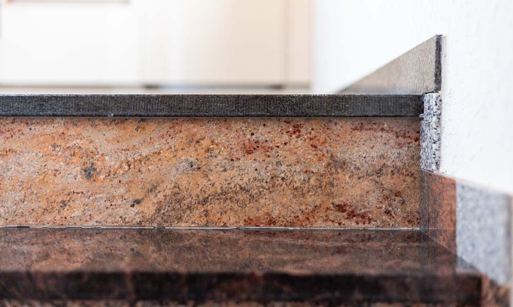 Eine Nahaufnahme einer Granitarbeitsplatte in einer Küche.