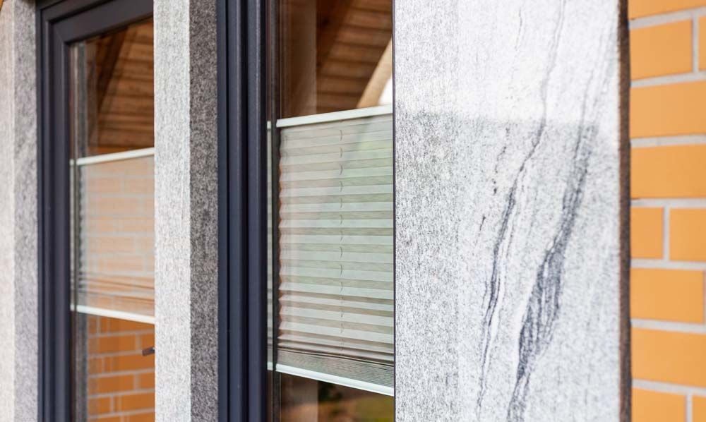 Eine Nahaufnahme eines Fensters mit einer Backsteinmauer im Hintergrund.