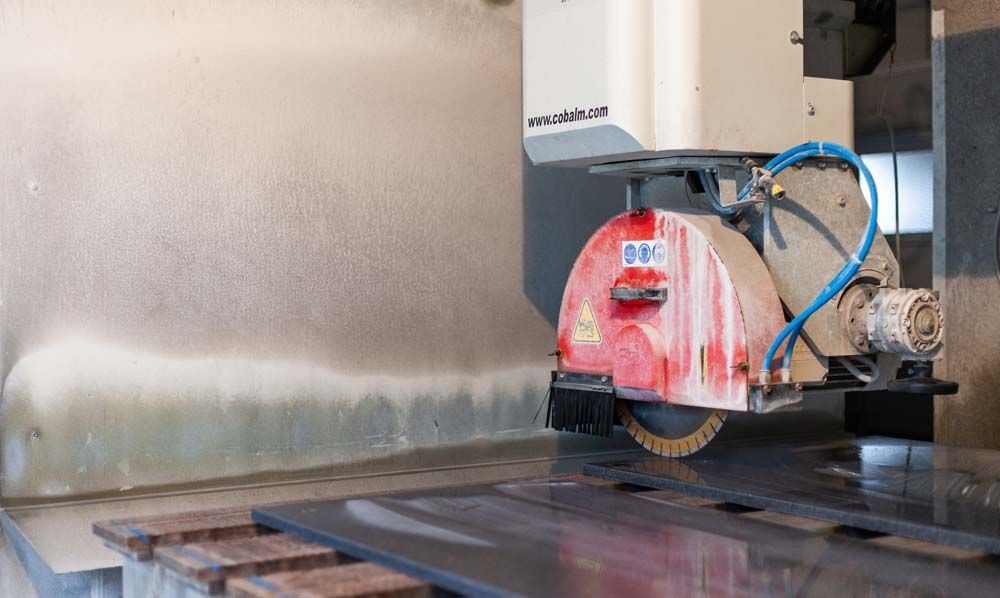 Eine Maschine schneidet ein Stück Metall auf einem Tisch.