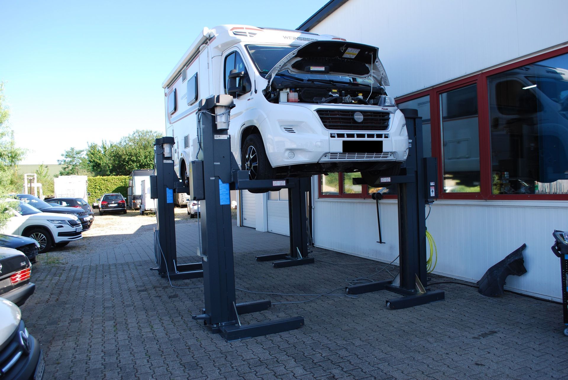 Wohnmobil auf Hebebühne vor Werkstatt – spezialisierte Wartung und Reparatur von Reisemobilen