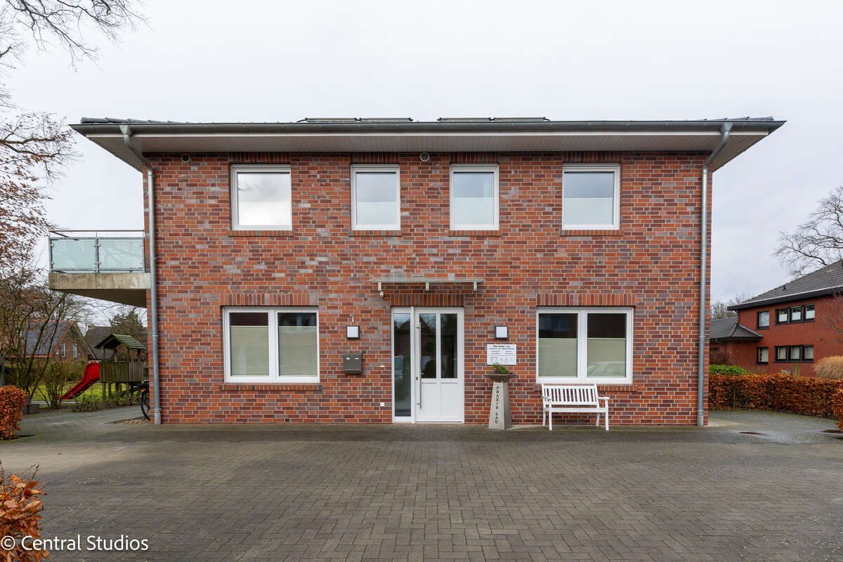 Ein großes Backsteingebäude mit einer Bank davor