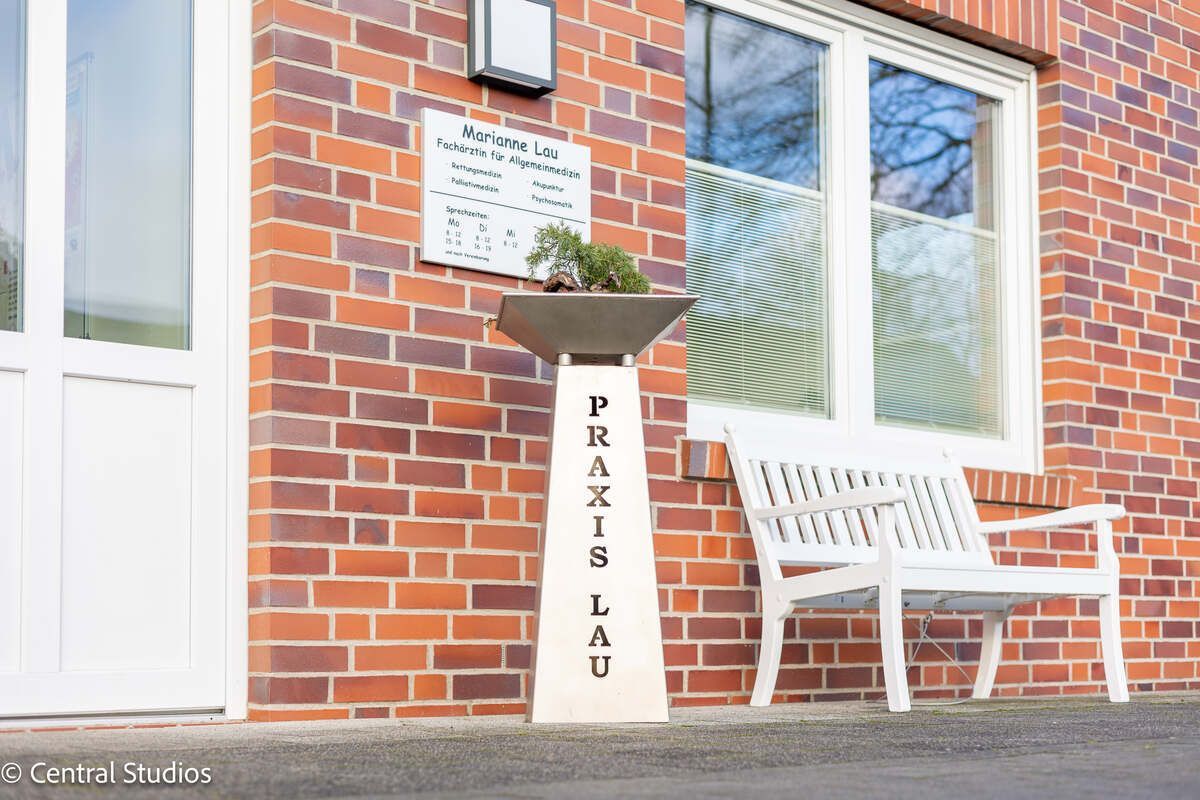 Hausarztpraxis für Allgemeinmedizin mit einer weißen Bank davor