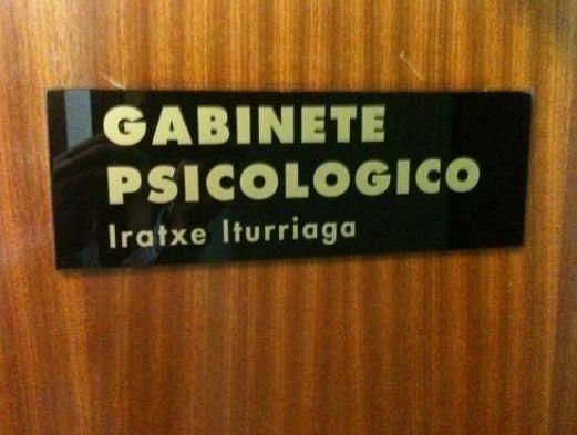 Un letrero negro en la puerta de madera dice “GABINETE PSICOLOGICO” e “Iratxe Iturriaga”.
