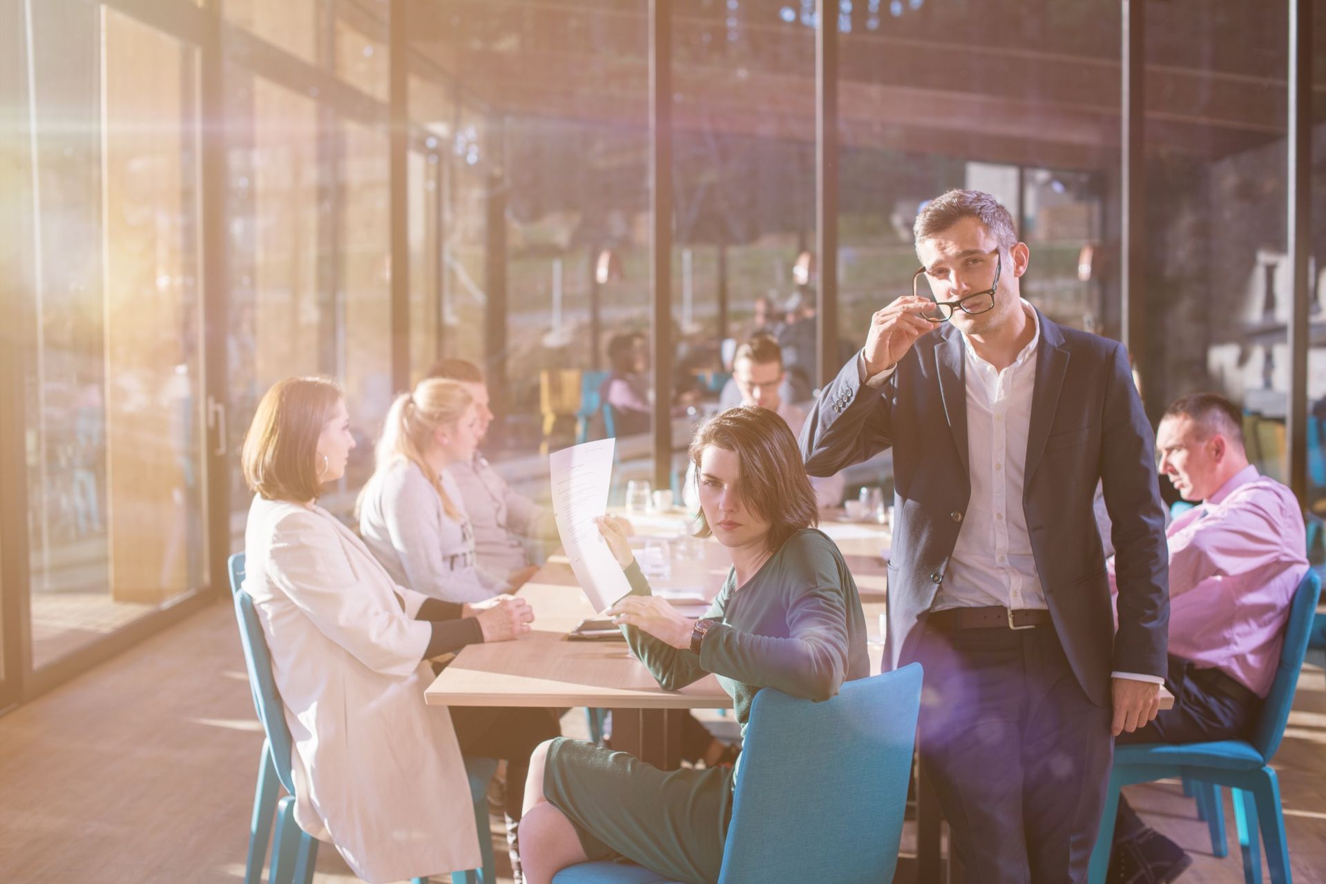 Un grupo de personas están sentadas en mesas en un restaurante teniendo una reunión.