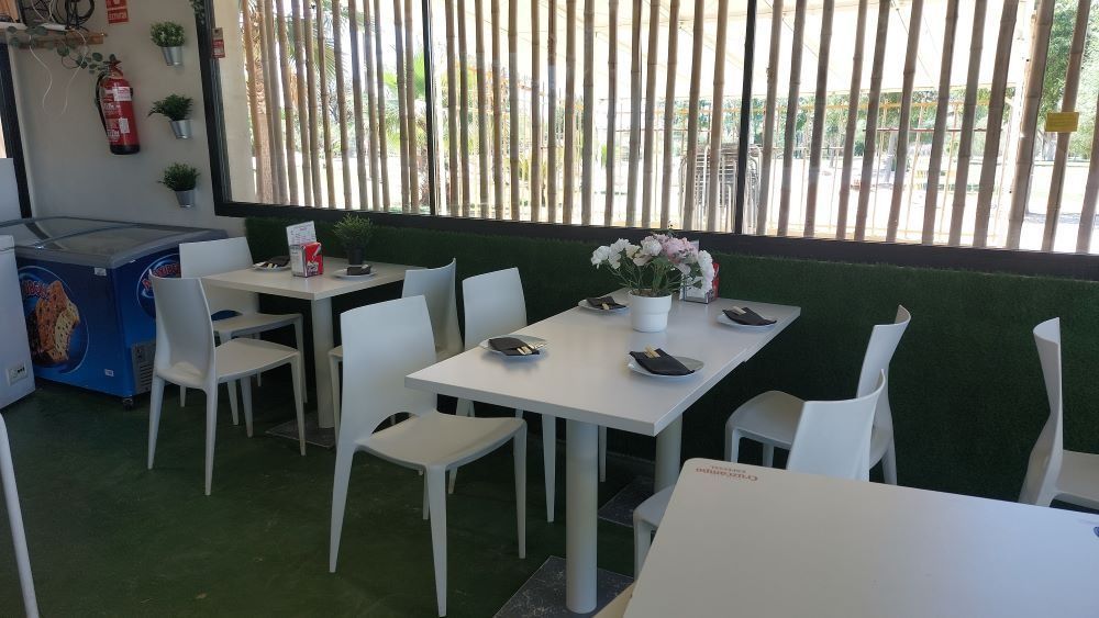 Un restaurante con mesas y sillas y un congelador.