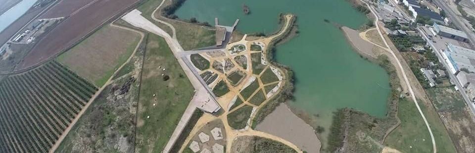 Una vista aérea de un lago rodeado de campos y árboles.
