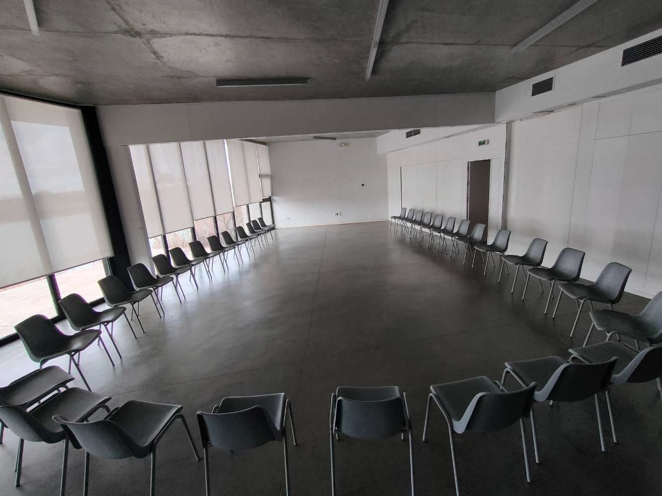 Una fila de sillas están alineadas en círculo en una habitación grande.