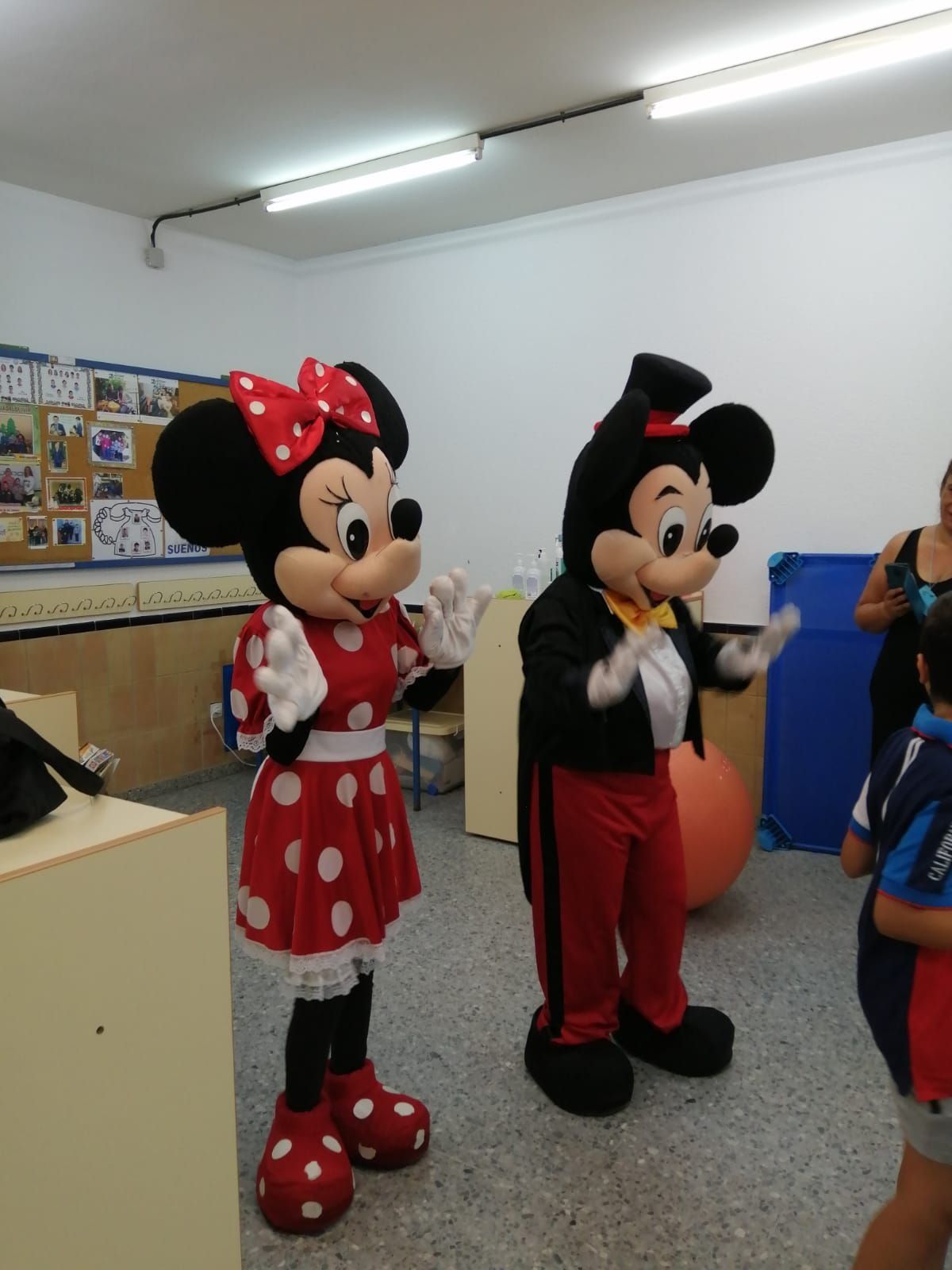 Las mascotas de Minnie Mouse y Mickey Mouse están una al lado de la otra en una habitación.