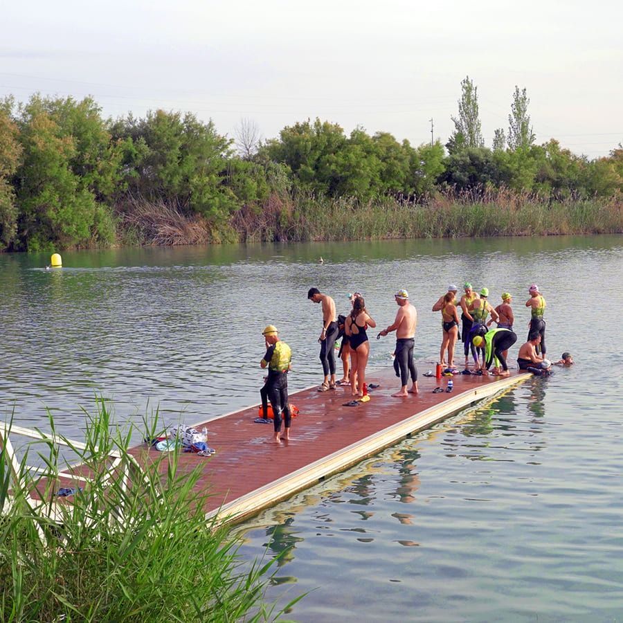 Un grupo de personas está de pie en un muelle en el agua.