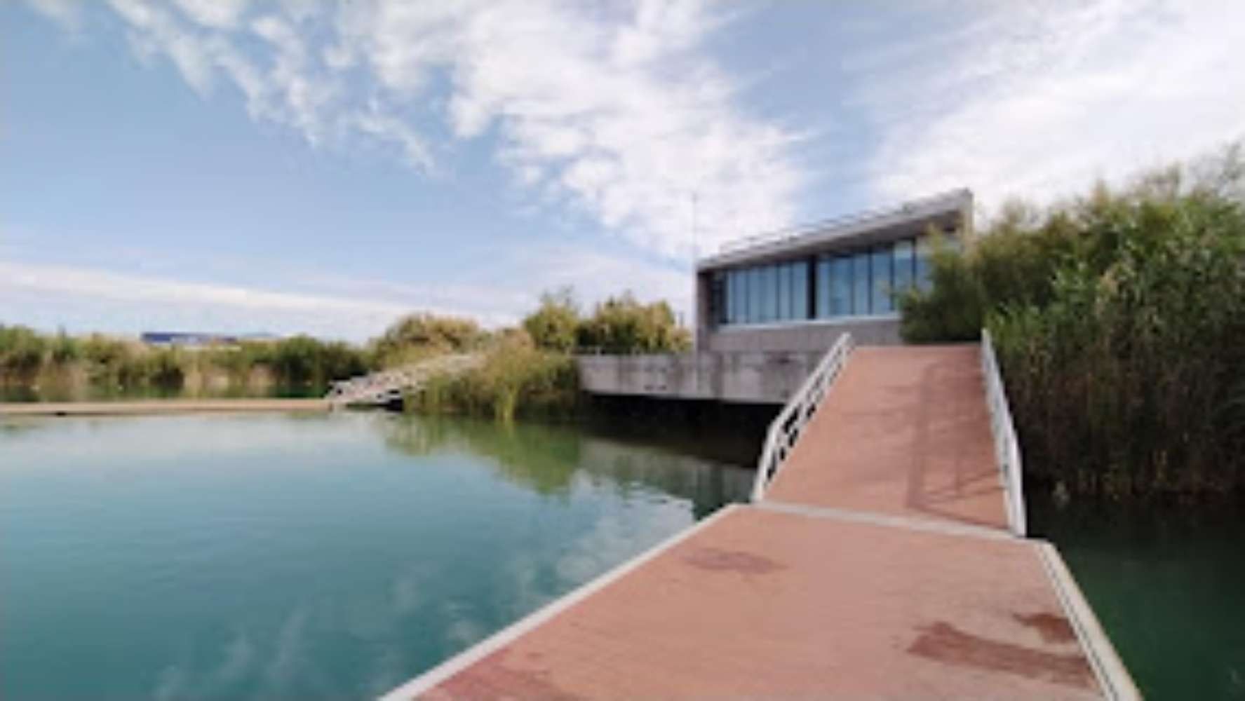 Un muelle que conduce a un edificio sobre un cuerpo de agua.