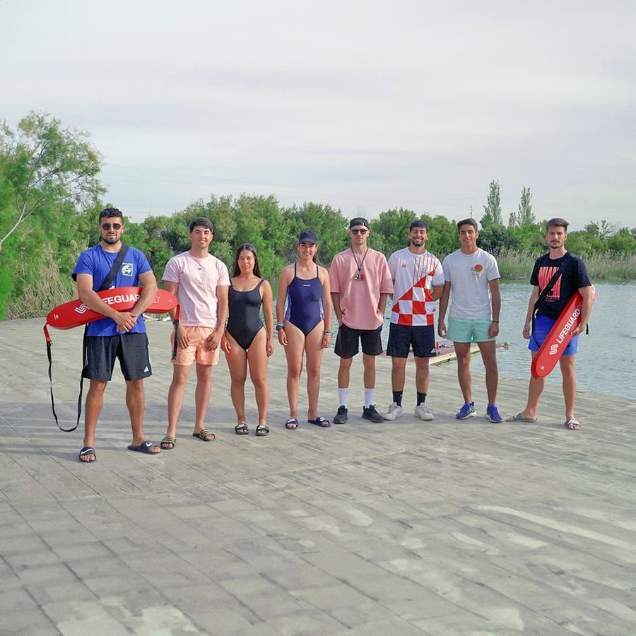 Un grupo de personas paradas una al lado de la otra en una playa