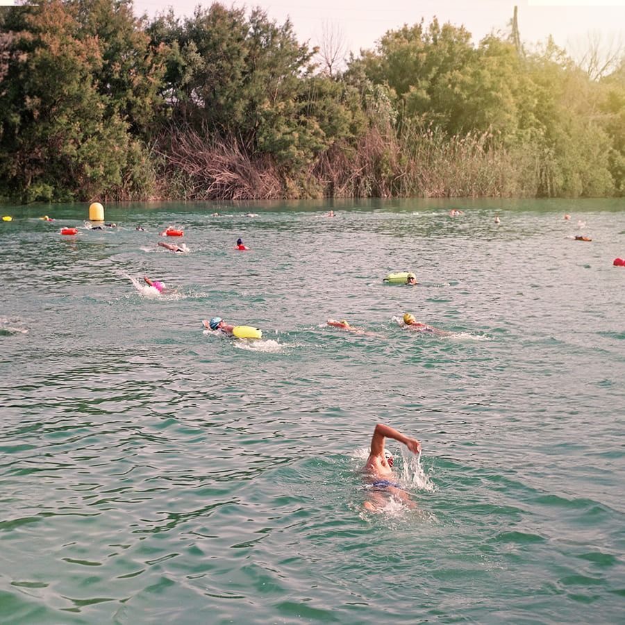 Un grupo de personas está nadando en un lago.