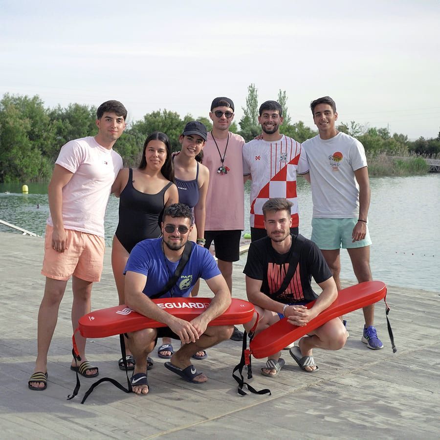 Un grupo de personas posando para una foto con un cartel de salvavidas.