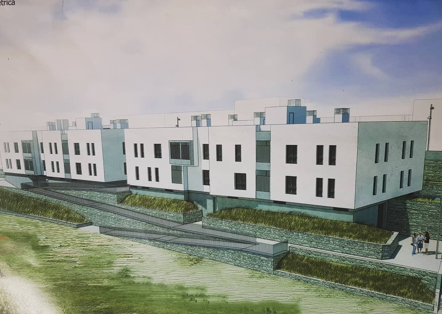 Modernos edificios de apartamentos blancos en una ladera ajardinada bajo un cielo nublado.