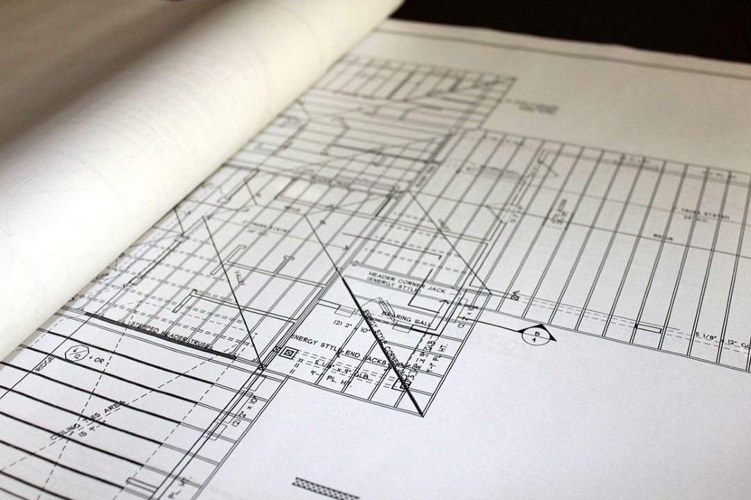 Plano arquitectónico con líneas de cuadrícula y marcas a lápiz sobre papel.