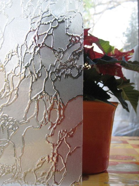 Bemustertes Glas vor Blumentopf