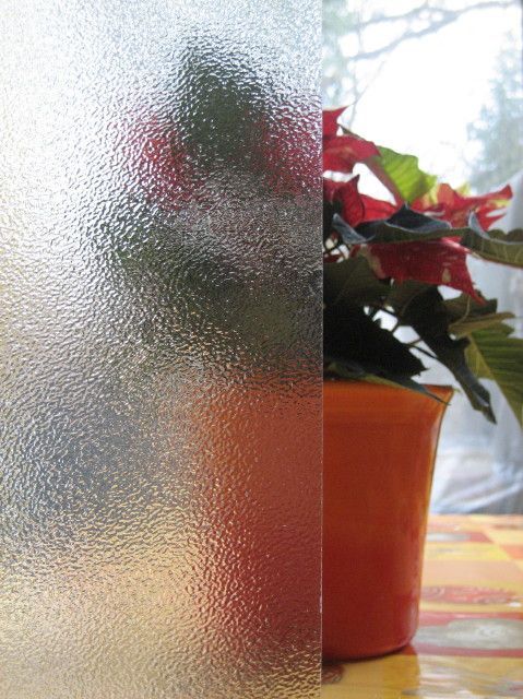 Milchiges Glas mit Muster vor Blumentopf