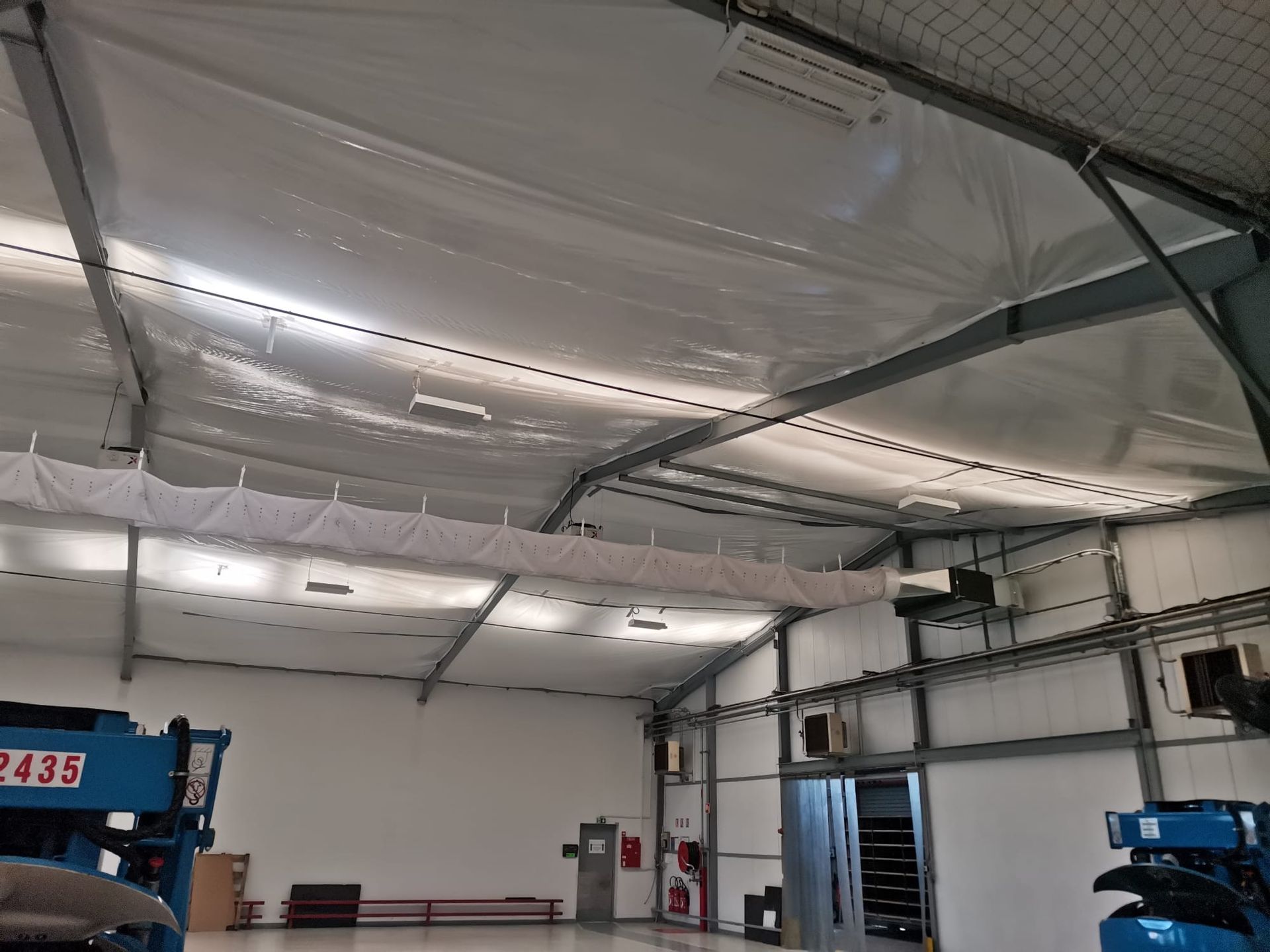 Une personne portant des gants rouges applique du mastic sur un cadre de fenêtre.