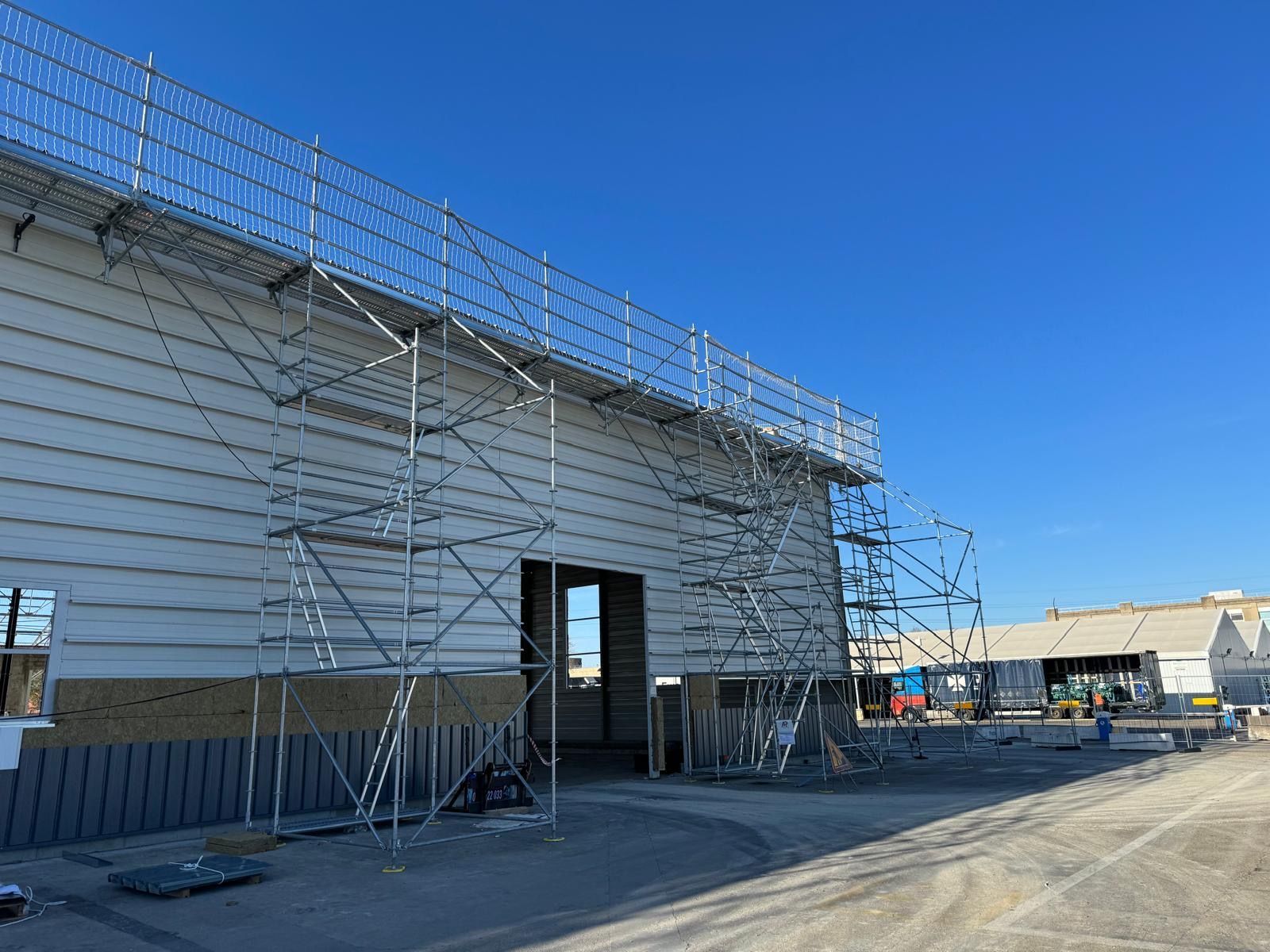 Échafaudages le long d'un bâtiment en construction par une journée ensoleillée.