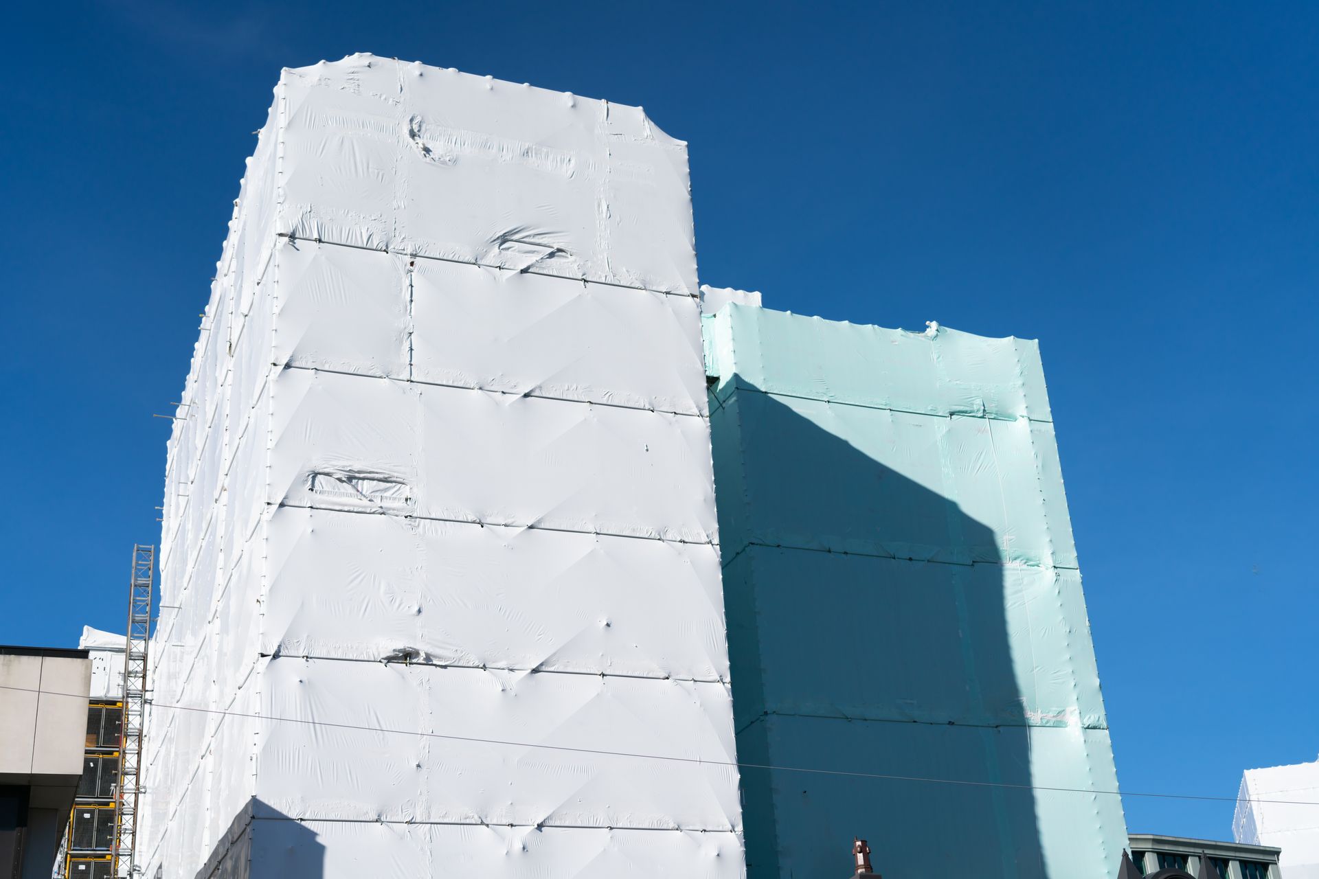 Des blocs de mousse blanche et bleue empilés sur un ciel bleu vif, probablement destinés à la construction ou à l'isolation.