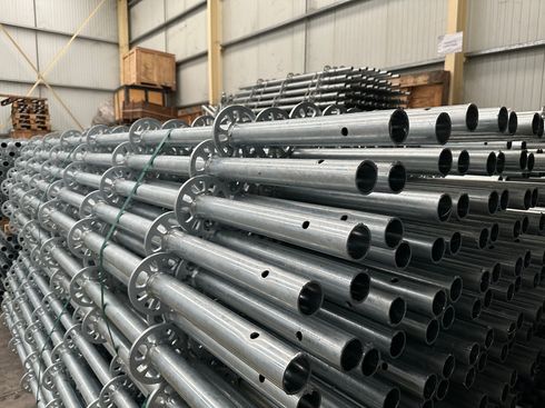 Vue aérienne : échafaudage avec filet de sécurité vert, poutres métalliques et corde.