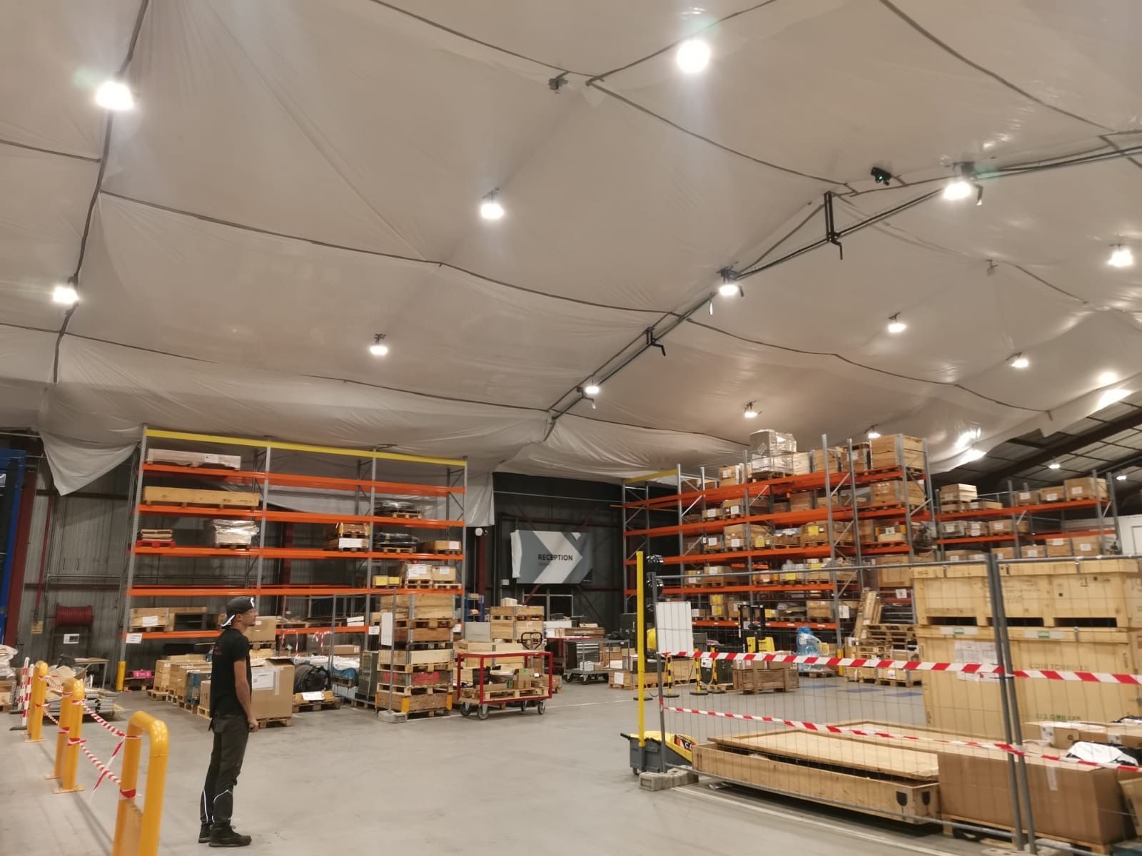 Intérieur d'un gymnase avec charpente métallique, paniers de basket et fenêtres.