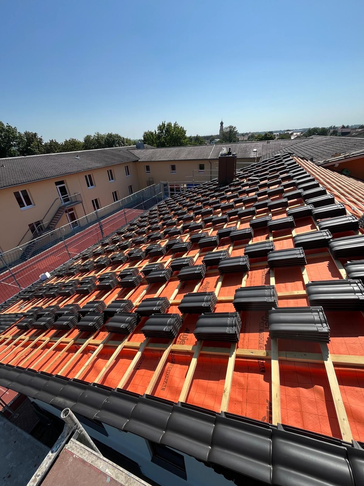Beim Bau der hölzernen Dachsparren im Hintergrund scheint die Sonne.