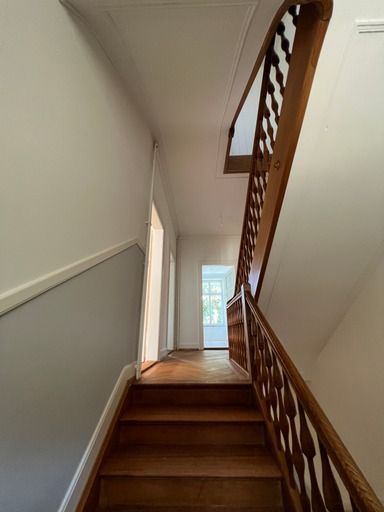 Ein Flur mit Holztreppe und Holzgeländer