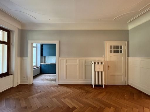 Ein leerer Raum mit Holzboden und Heizkörper.